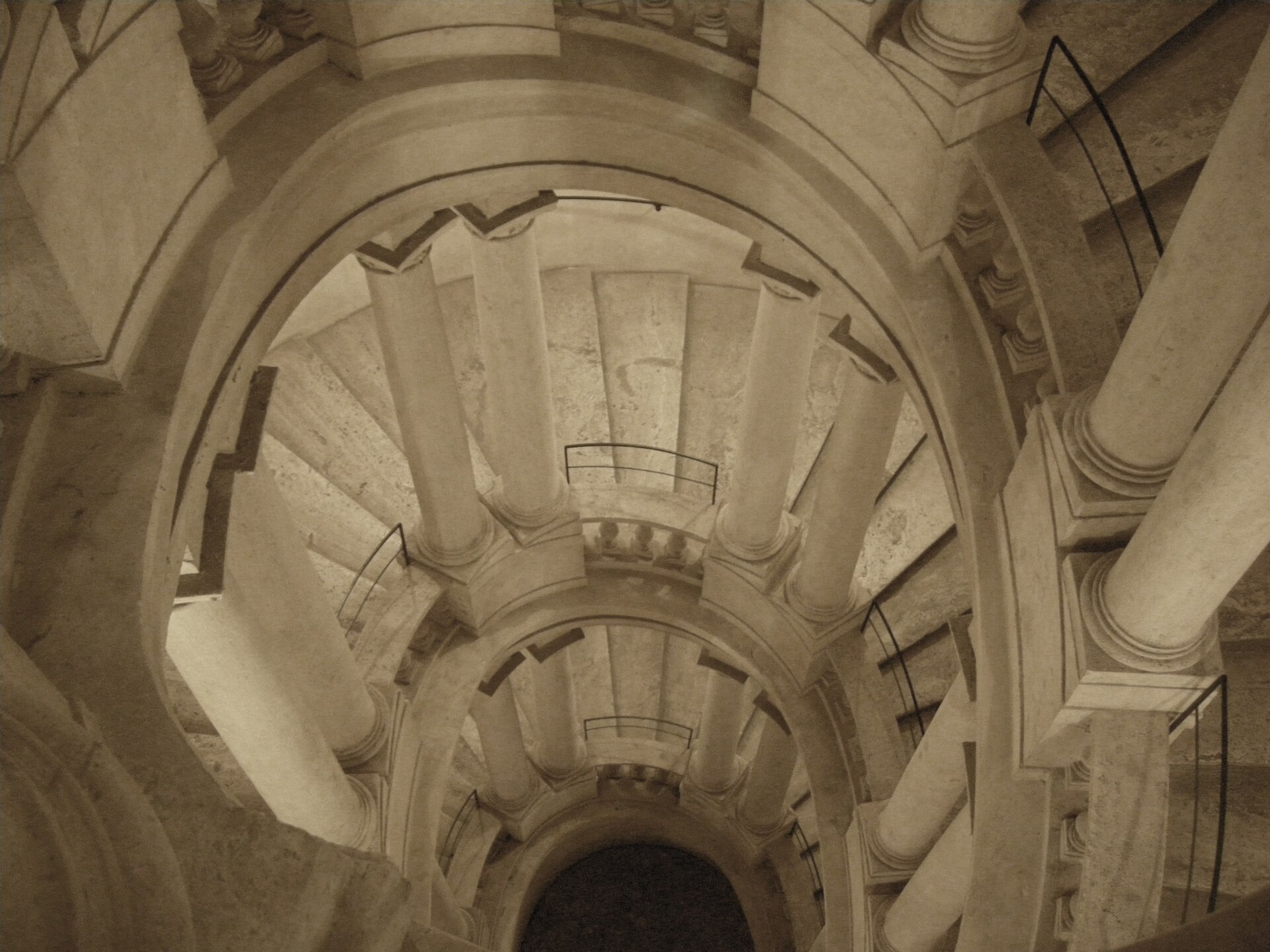 Scala elicoidale di un palazzo storico italiano, veduta prospettica dall'alto.